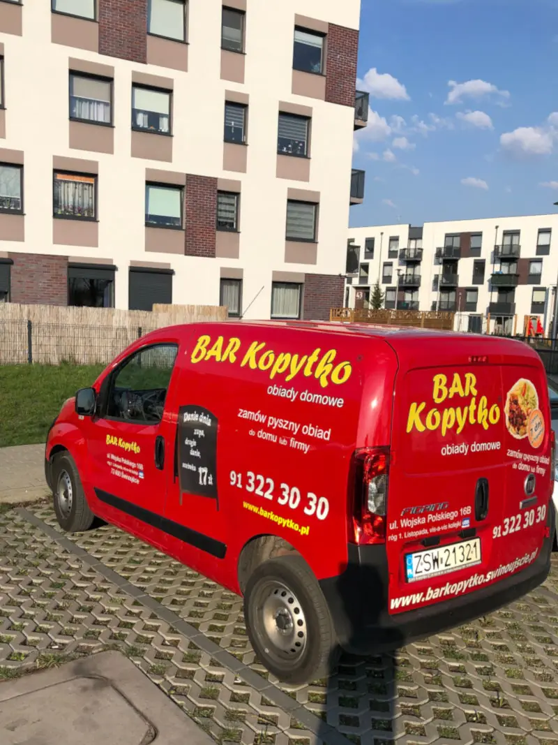 Czerwone auto Baru Kopytko pod blokiem